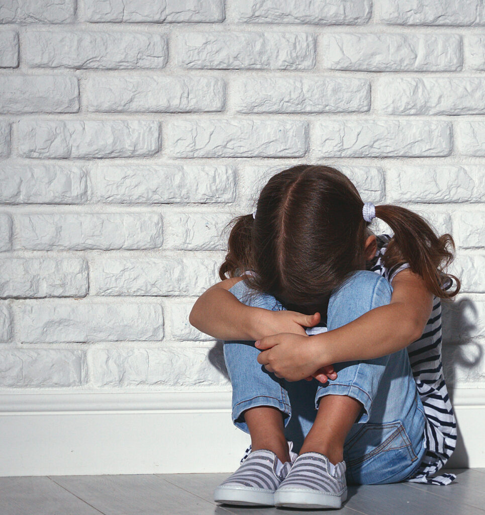 upset sad sad child girl in stress cries at an empty dark wall By JenkoAtaman
