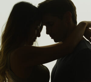 Interracial couple being intimate in front of window By rocketclips