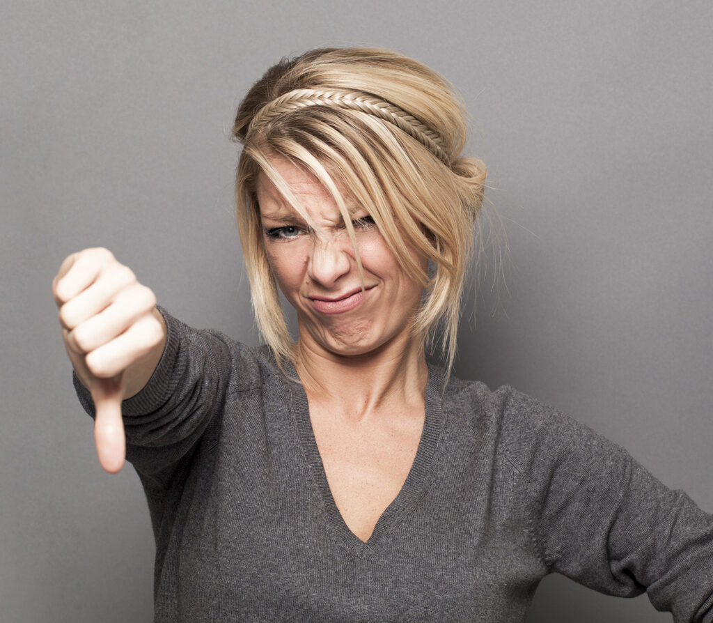 disappointment concept for offended young woman with thumbs down, banner By STUDIO GRAND WEB
