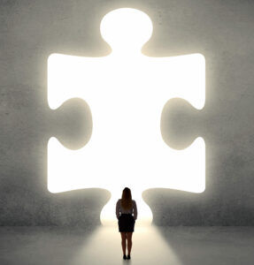 Woman standing and looking to a big puzzle piece By ra2 studio