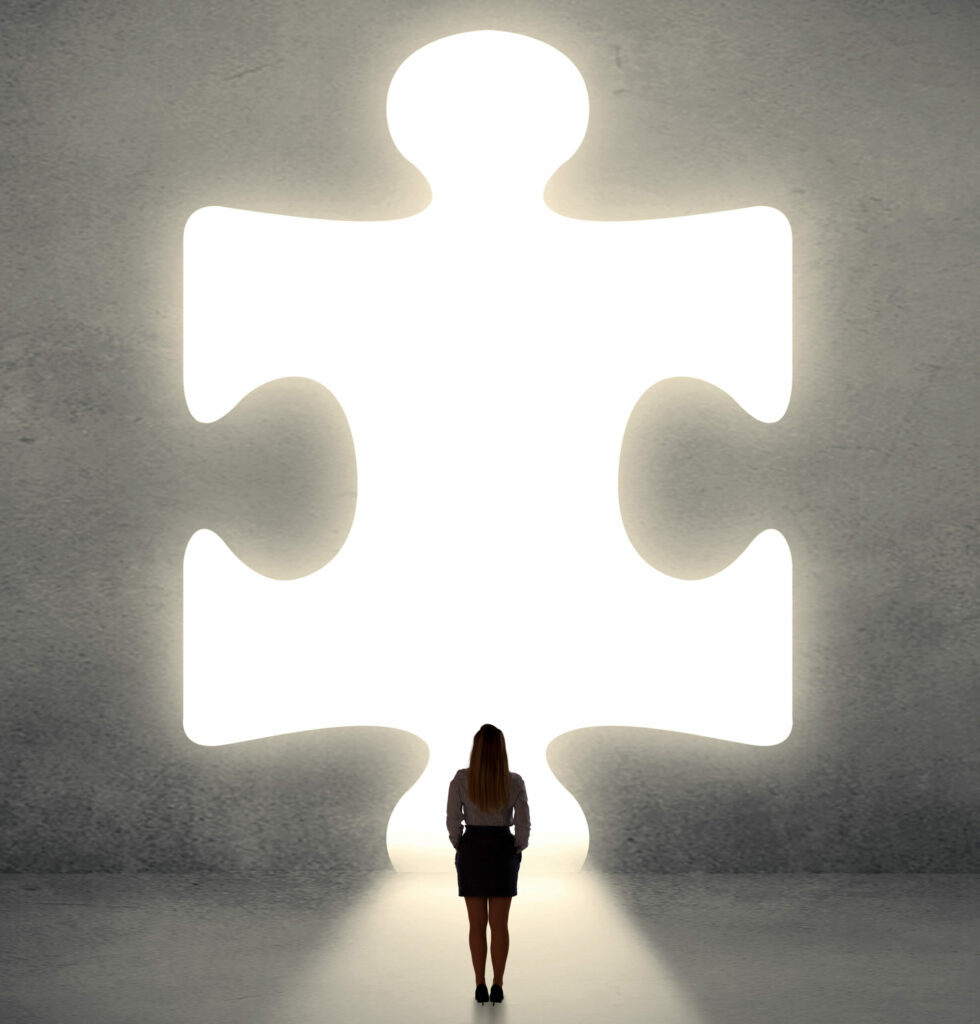 Woman standing and looking to a big puzzle piece By ra2 studio